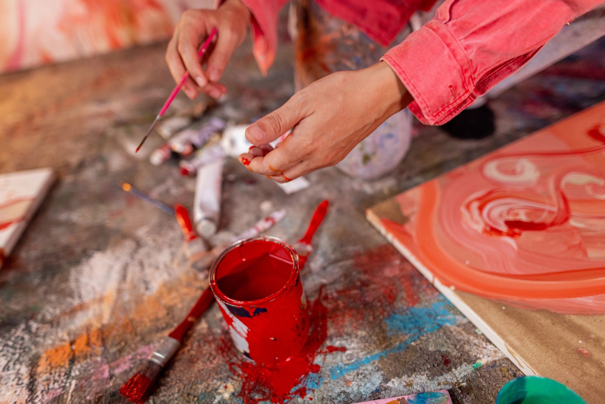 Artist painting in a home studio with red tones