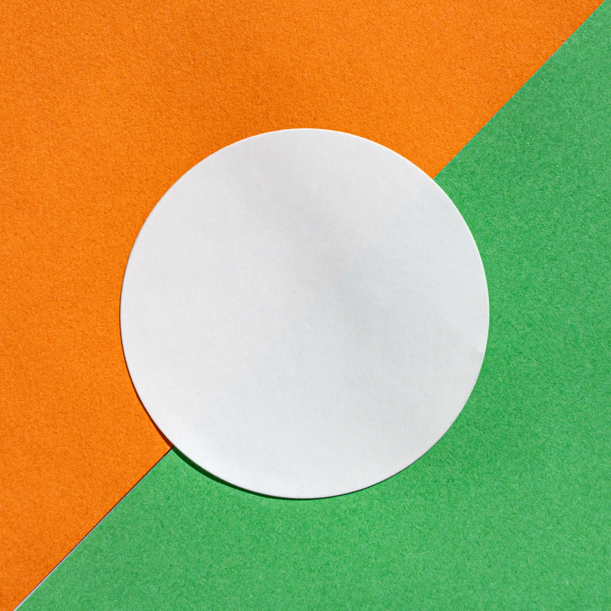 Minimalist circular white paper on orange and green background